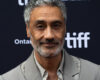 Taika Waititi at the 2023 Toronto International Film Festival, wearing a grey suit.