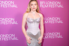 Florence Pugh at the 2026 BFI London Film Festival in a silver gown against a pink backdrop.