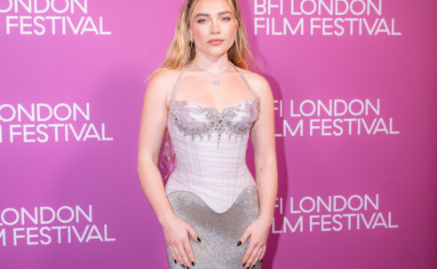 Florence Pugh at the 2026 BFI London Film Festival in a silver gown against a pink backdrop.