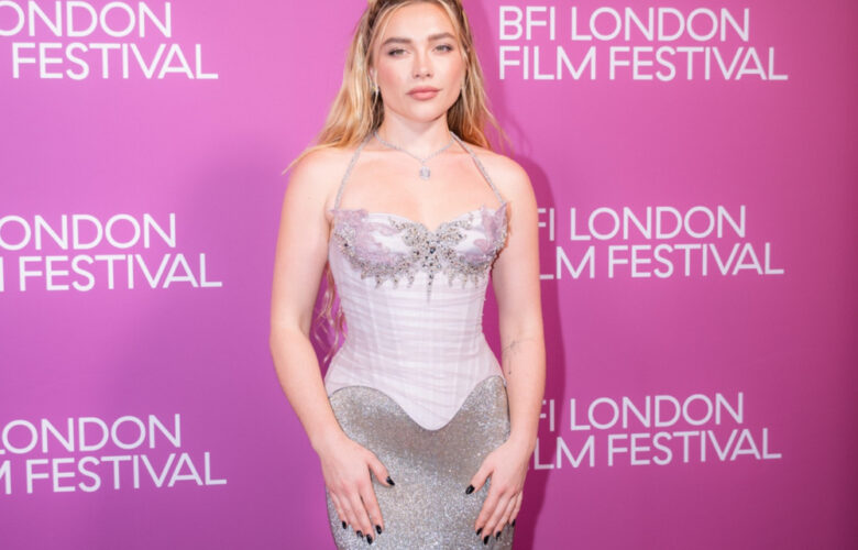 Florence Pugh at the 2026 BFI London Film Festival in a silver gown against a pink backdrop.